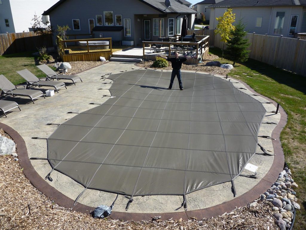 man standing on safety pool cover
